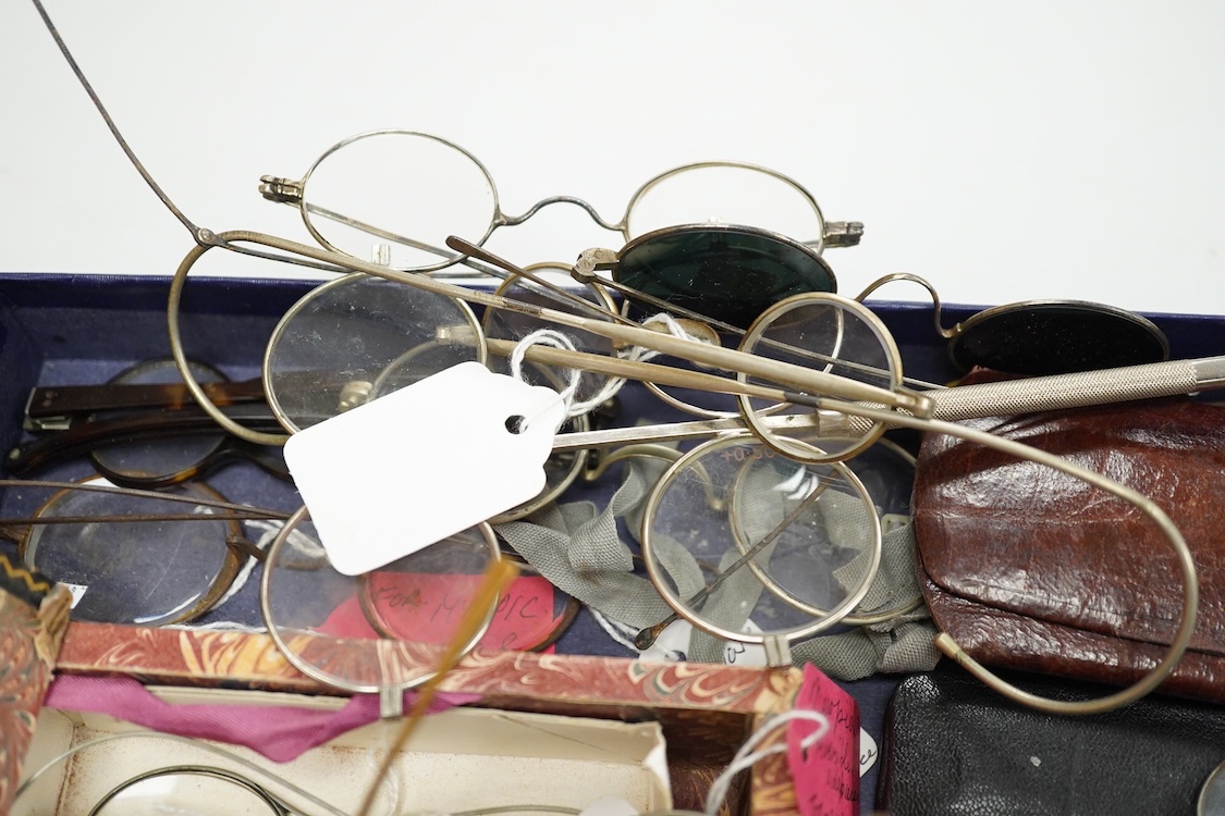 A collection of 18th-20th century steel, nickel, tortoiseshell, brass or faux tortoiseshell spectacles, some cased, five 19th century pince nez, some cased and a quizzing glass etc.
